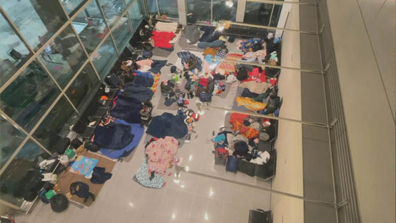 migrants sleeping on the floor of Terminal E at Logan Airport